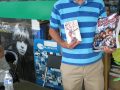 Author Maurey Dean displays a first edition of his Rock Revolution (1966) and his new reissue Rock Revolution Rolls On.